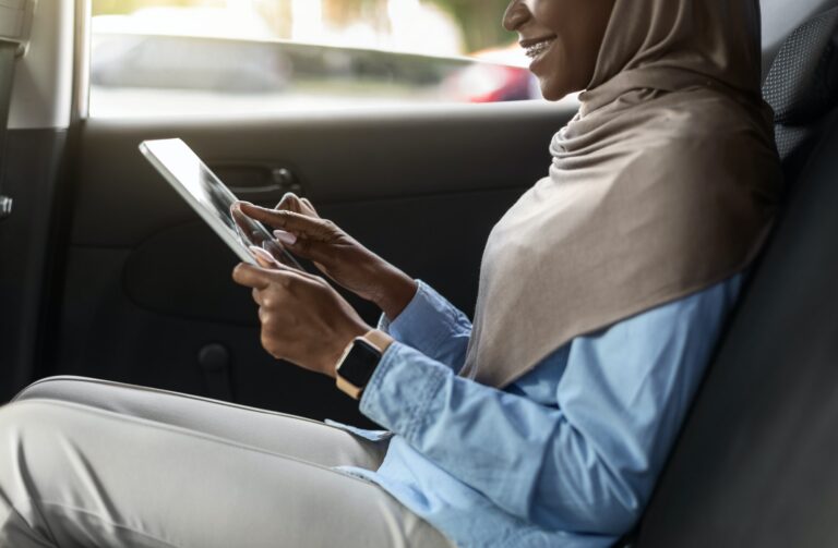 unrecognizable-african-lady-in-hijab-using-digital-tablet-on-backseat-in-taxi.jpg